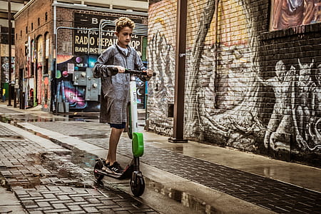 Boy Standing on Black and White Kick Scooter thumbnail