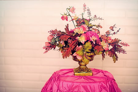 pink petaled flower with vase on table covered with pink tablecloth thumbnail