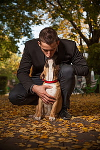 man in black suit and brown American pit bull terrier outdoor thumbnail