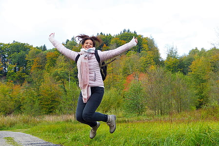 woman wearing jacket and blue denim jeans jumping thumbnail