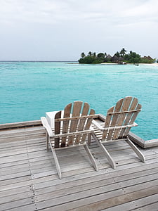two brown wooden adirondack chairs in front ocean at daytime thumbnail
