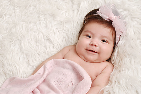 close up photo of baby lying on white textile thumbnail