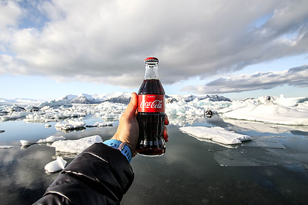 person holding Coca-Cola beverage bottle thumbnail