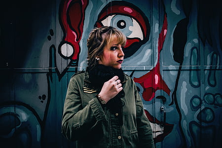 selective focus photography of woman standing beside wall thumbnail