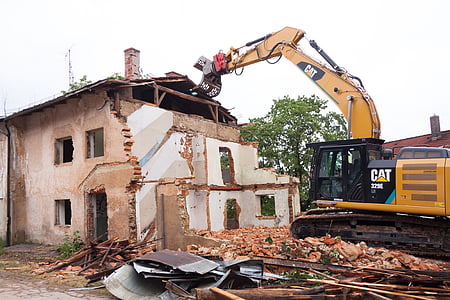 yellow CAT excavator wrecking house thumbnail