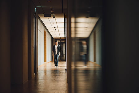 man walking on brown concrete floor near the gray wall thumbnail