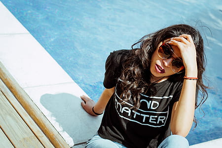 woman in black shirt sitting beside pool thumbnail
