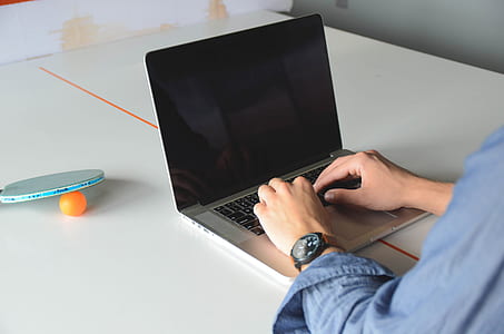 person wearing blue dress shirt using MacBook Pro thumbnail