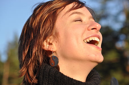 woman in black sweater laughing with eyes close thumbnail