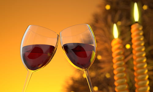 two clear wine glasses with red liquids near two white candle sticks in tilt shift photography thumbnail