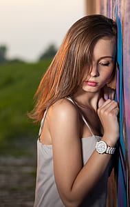 woman wearing white top leaning on wall thumbnail