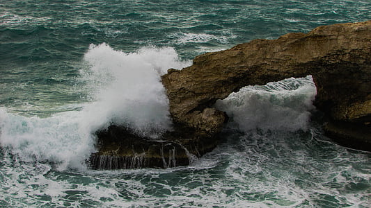 ocean waves on brown rock formation thumbnail