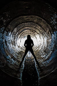 Silhouette of Person Inside Concrete Drainage thumbnail