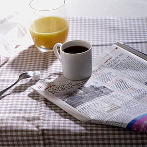 black liquid filled in white mug on newspaper thumbnail