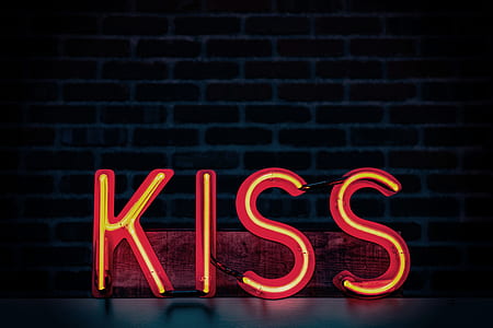 orange kiss neon light signage near brick wall thumbnail