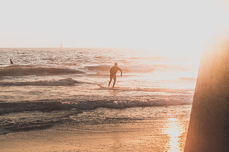 man doing surfing on seashore during golden hour thumbnail