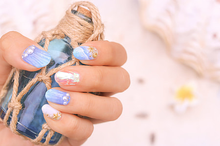 human's left hand holding blue glass vial during daytime thumbnail