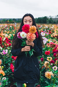 woman holding assorted-color petaled flowers thumbnail