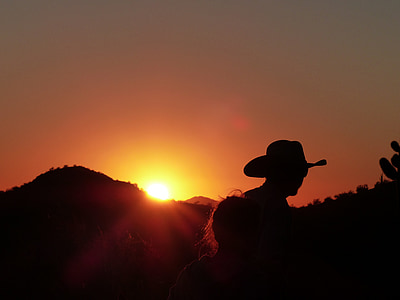 silhouette of man wearing cowboy hat during golden hour thumbnail