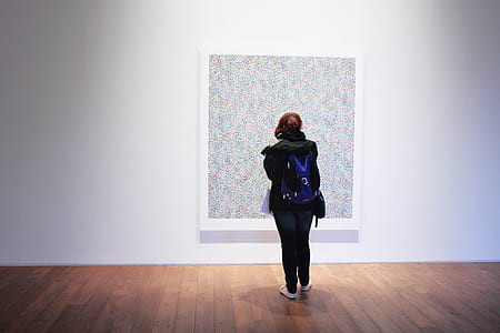 Woman Standing Infront of a Wall Mount Painting thumbnail