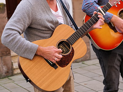 person holding guitar while playing beside person playing guitar at daytime thumbnail