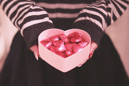 person holding white heart box filled with candy bars thumbnail