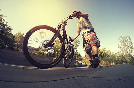 worm's-eye view of person holding bicycle thumbnail