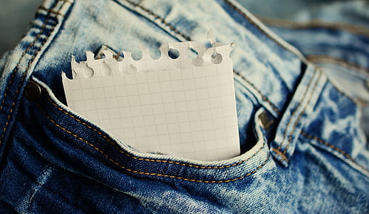 shallow focus of white paper in jeans thumbnail