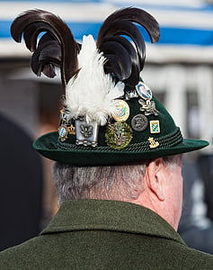 close-up photography of man's green hat and assorted badges thumbnail