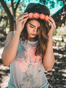 selective focus photography of woman in grey and pink floral shirt wearing pink flower headband thumbnail
