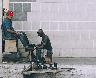man in blue denim pants cleaning shoes thumbnail