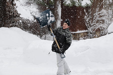 boy throwing snow holding shovel thumbnail