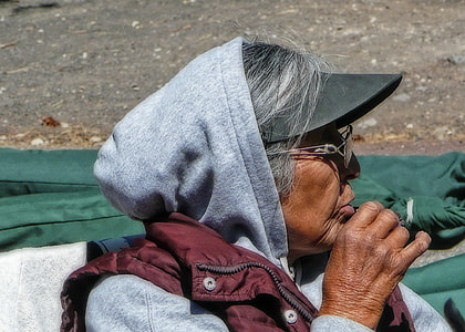 woman wearing grey hoodie and black cap in close-up photograhy thumbnail
