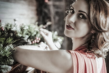 woman wearing orange sleeveless tops near pine tree leaves thumbnail