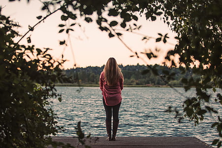 woman wearing reed shirt with pants standing near river thumbnail