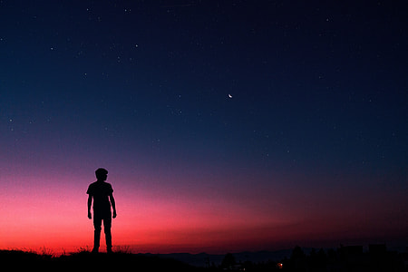 Silhouette of man standing on summer night thumbnail
