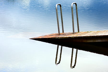 brown wooden sea dock near body of water at daytime thumbnail