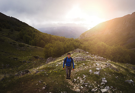 man standing on grass field mountain thumbnail