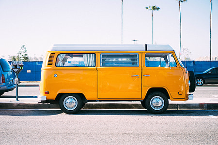 yellow and white bus parked on side of road thumbnail