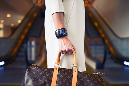 selective focus photo of person holds Louis Vuitton Monogram Canvas leather handbag thumbnail