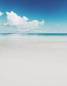 white sands near ocean water under sunny cloudy sky thumbnail