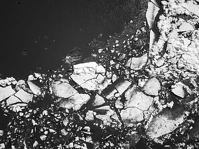 grayscale photography of rock formations near body of water thumbnail