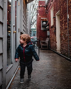 boy in hoodie walking in narrow street thumbnail