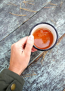 Person Holding Black and White Ceramic Coffee Cup Filled With Coffee thumbnail