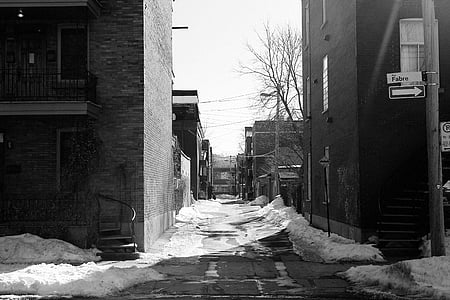 grayscale photo of two buildings with snow on pavement during daytime thumbnail