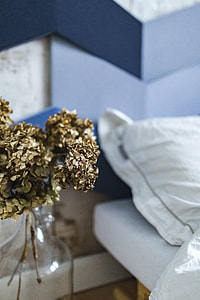 Designer bedroom with an ornamental golden plant in a jar by the bed thumbnail