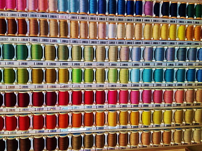 assorted-color thread spool lot on rack thumbnail