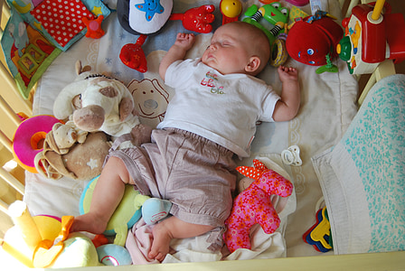 baby sleeping while surrounded by toys thumbnail