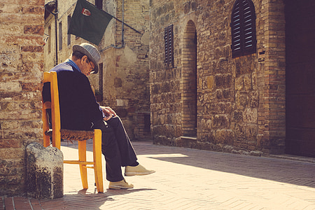 man sitting on yellow chair while looking downwards thumbnail