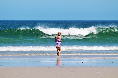woman in purple tank top standing on seashore thumbnail